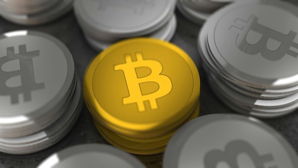 Gold Bitcoin coin among silver coins