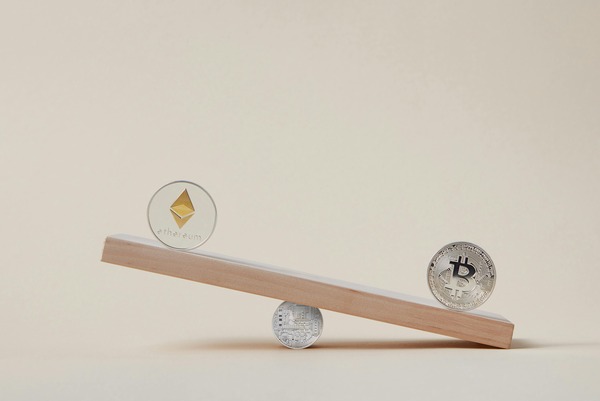 Wooden seesaw balancing crypto coins