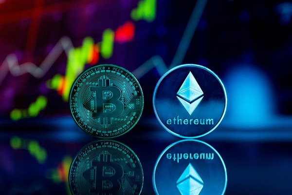 Bitcoin and Ethereum coins under neon chart lights