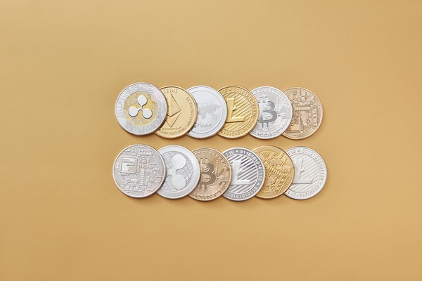Rows of crypto coins arranged on a beige surface
