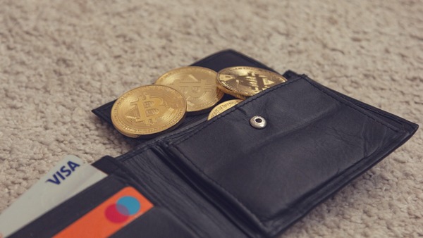 Leather wallet holding gold crypto coins