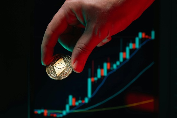 Hand placing a coin over a rising price chart