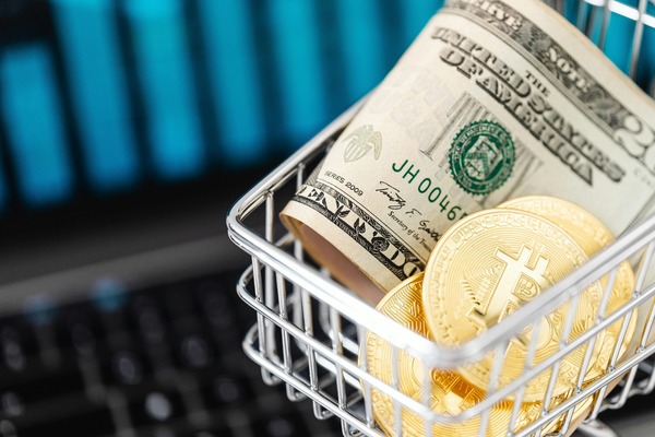 Shopping cart filled with dollar bills and crypto coins