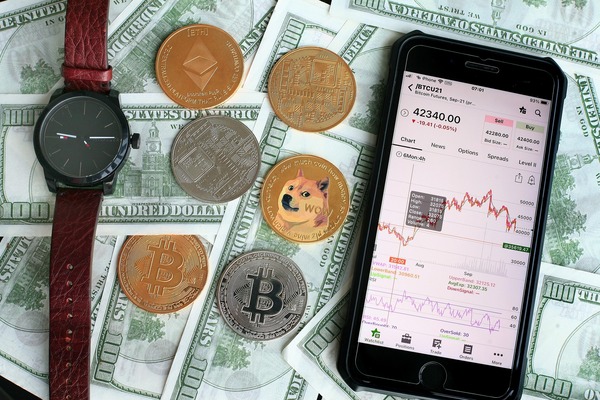 Smartphone with a crypto app next to coins and dollar bills